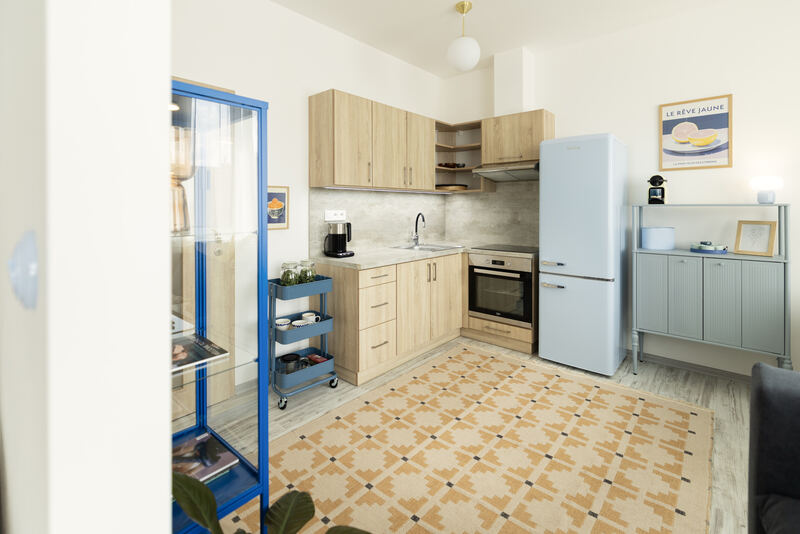 Kuchyňský kout s barevnou dlažbou a modrým servírovacím vozíkem