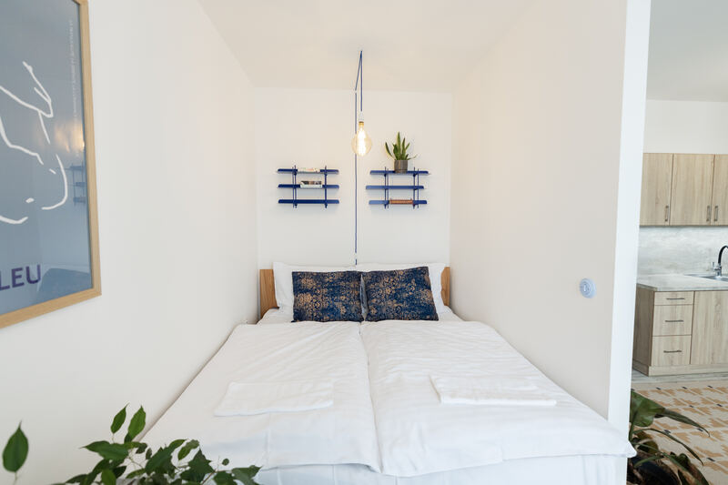 Velká manželská postel s čistým povlečením v designovém apartmánu ve Žďáře nad Sázavou